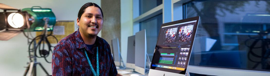 一名数字艺术专业的学生在皮马西部校园视频实验室的电脑上制作视频