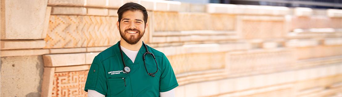 皮马大学西校区，一名护理专业的学生站在墙边微笑