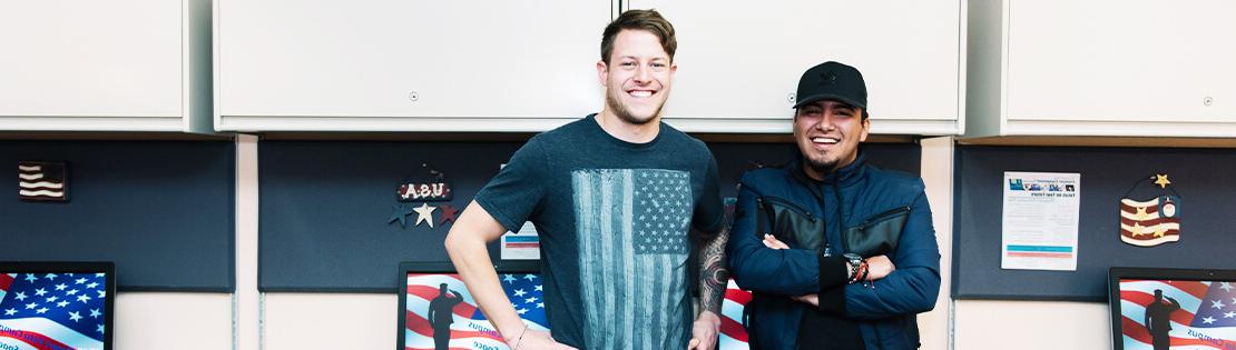 Two Military Students stand smiling in a Veterans Center